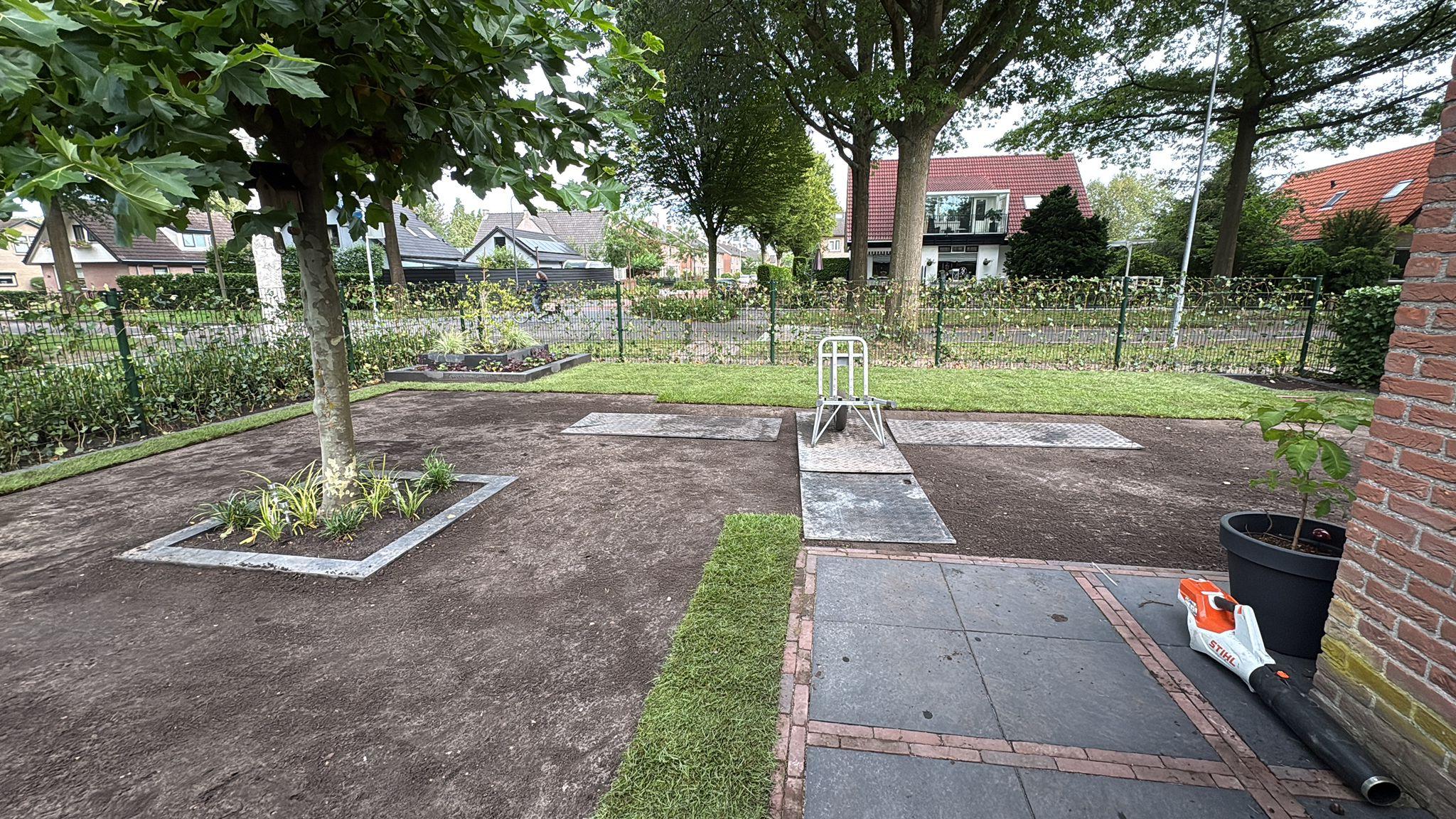 Graszoden worden gelegd tijdens de aanleg van het gazon door Franke Tuinen